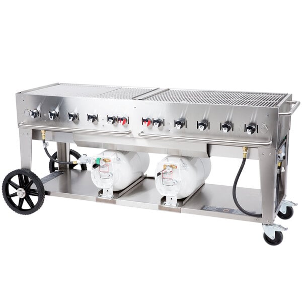 A large stainless steel Crown Verity outdoor grill with two horizontal propane tanks.