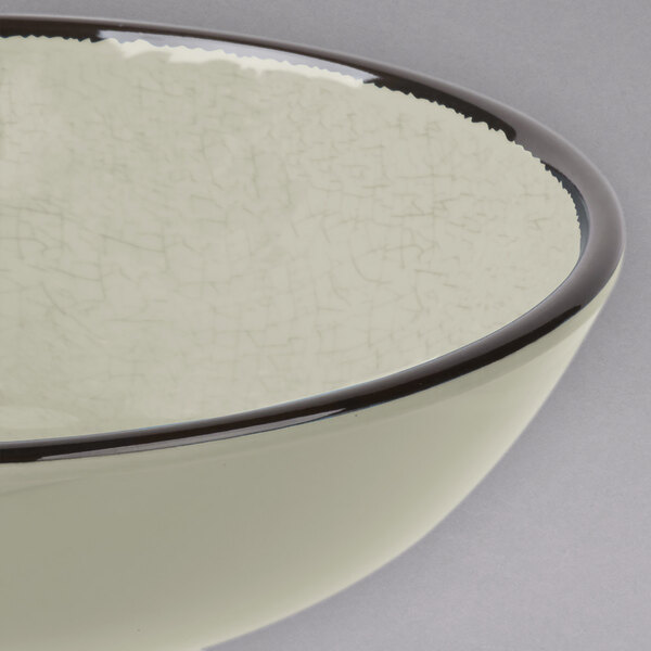 A white Elite Global Solutions round crackle bowl with a black rim.