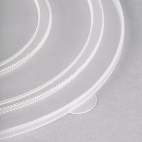 A stack of clear plastic Fineline catering bowl lids.