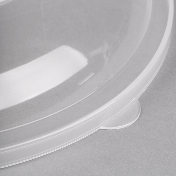A clear plastic lid with a plastic handle on a clear plastic catering bowl.