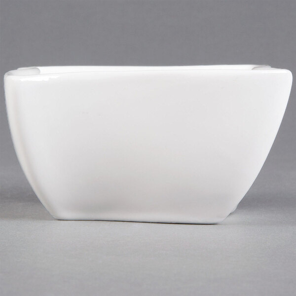 A white square American Metalcraft porcelain condiment cup with a handle.
