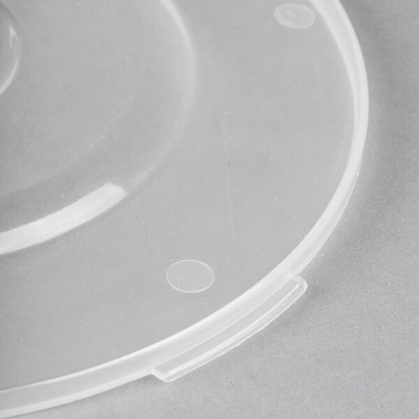 A close up of a clear plastic lid with a hole.