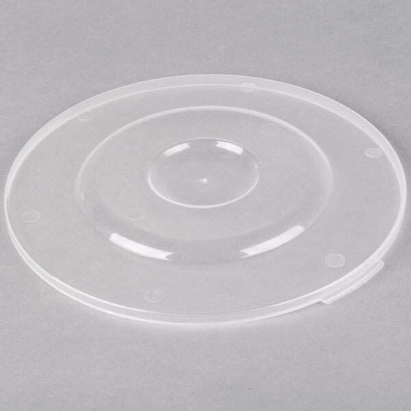 A clear plastic lid with a circular hole on a white surface.