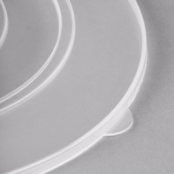 A clear plastic lid on a stack of clear plastic bowls.