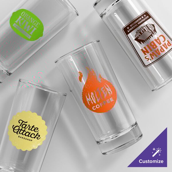 A set of clear Acopa Straight Up 14 oz. beverage glasses, each featuring a different custom printed logo or design.