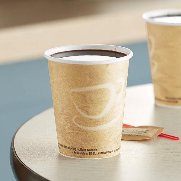 Two Solo Mistique paper hot cups filled with coffee on a table.