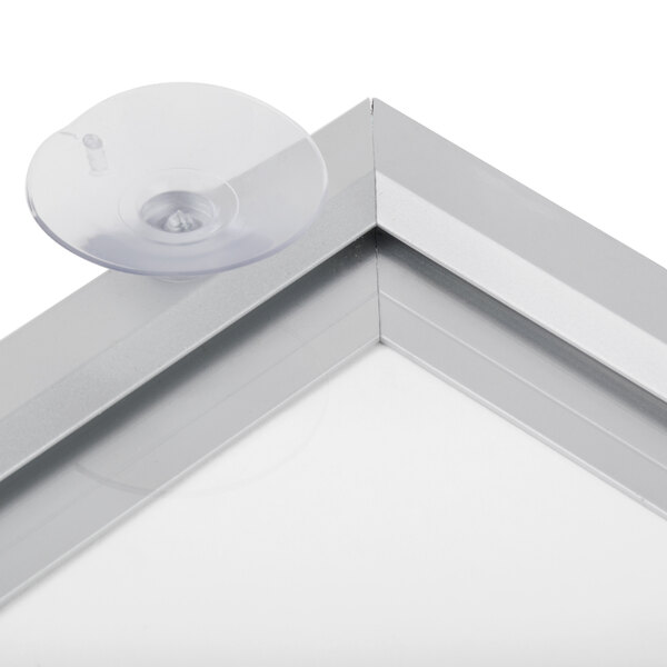 An Aarco aluminum window mount slide frame with a clear plastic disc with a hole in it.