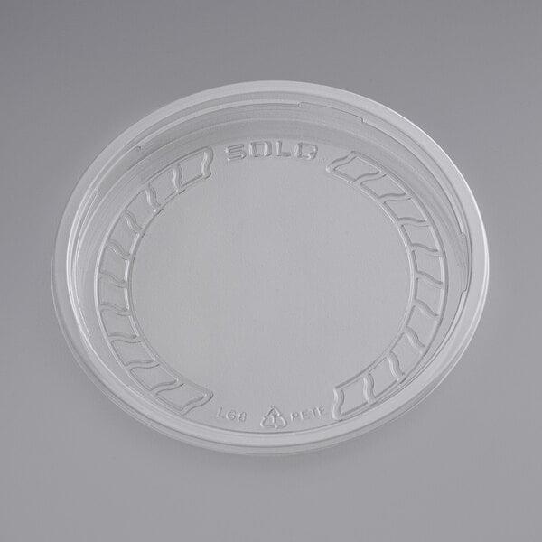 A white plastic lid with a circular design.