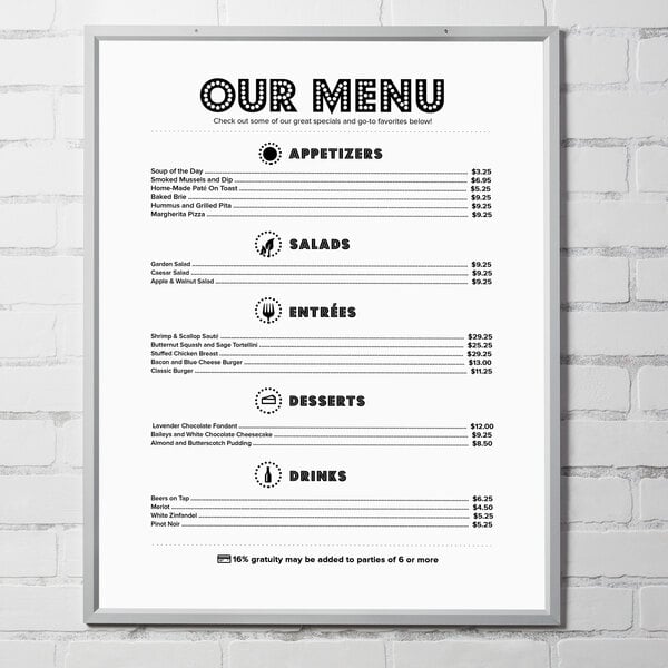 An Aarco aluminum slide frame with a white border displaying a menu with black text on a brick wall.