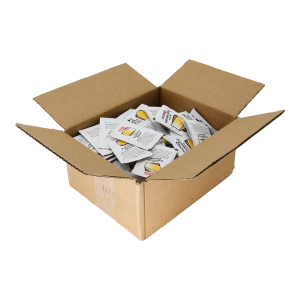 A cardboard box filled with small white packets of grated Parmesan cheese.