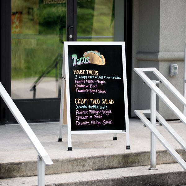 An Aarco A-Frame sign with a black write-on board that says "Taco" on it.