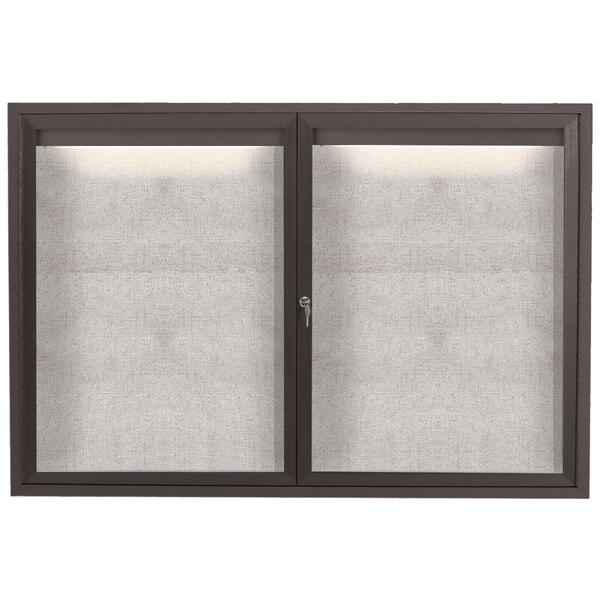 A close-up of the glass door of a bronze Aarco bulletin board.