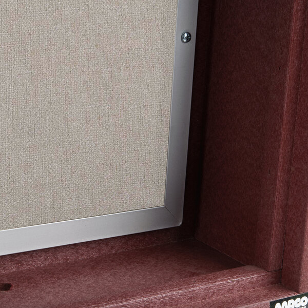 A rosewood Aarco outdoor message center with a vinyl board and a door.