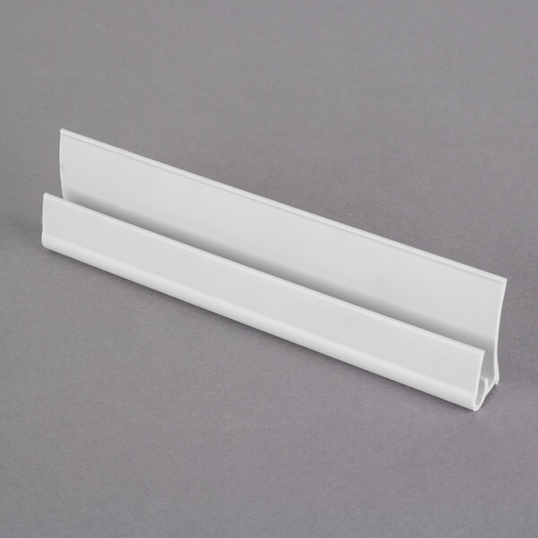A white plastic strip with a white Metro CSM6-WQ shelf marker on it.