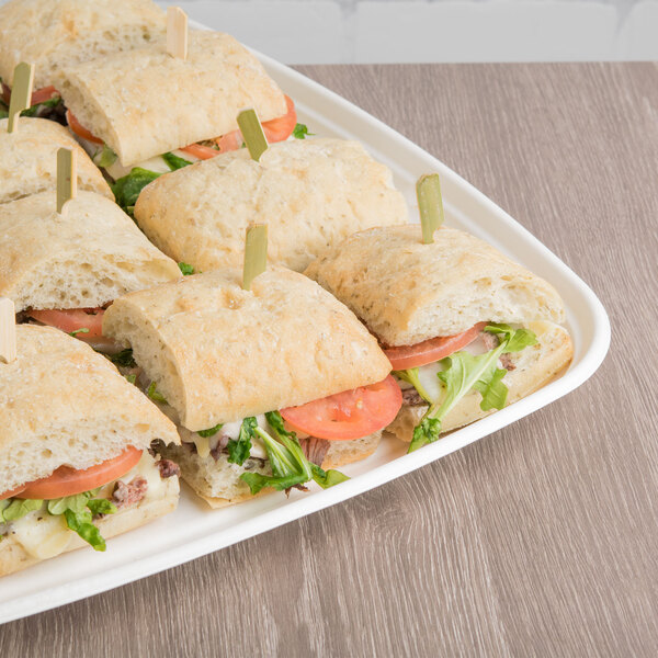 A white Eco-Products compostable sugarcane tray with sandwiches on toothpicks.