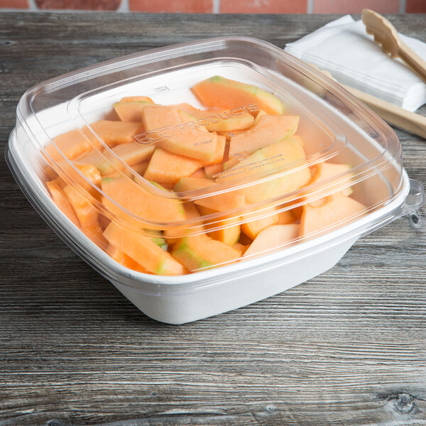 A close up of a clear plastic container filled with cantaloupe slices.