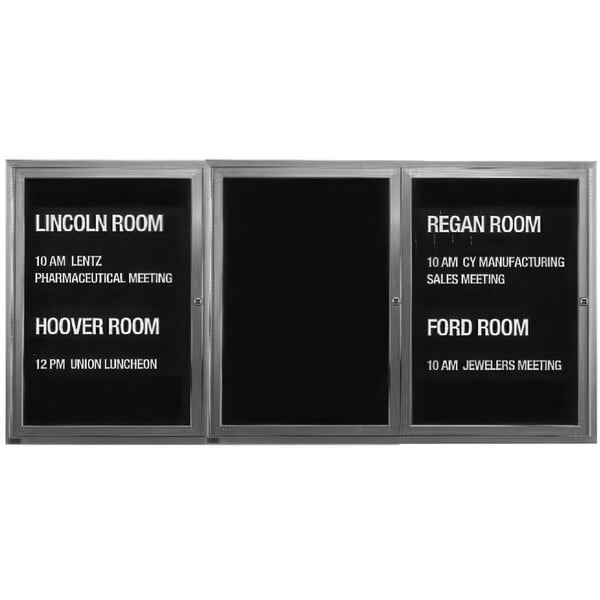 An Aarco enclosed black letter board with silver aluminum frame and 3 hinged doors.