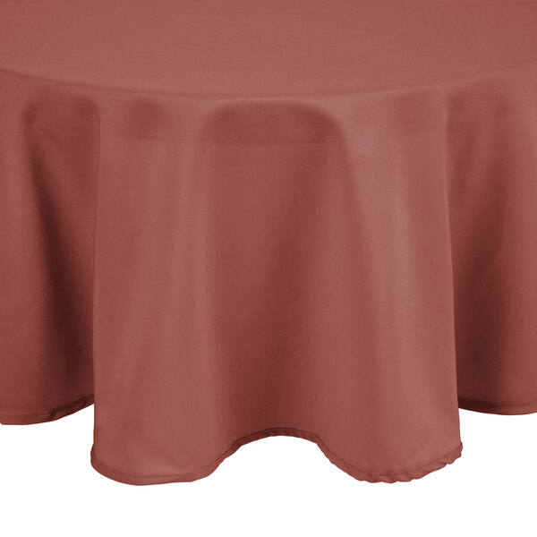 A mauve Intedge round tablecloth with a white hem on a table.