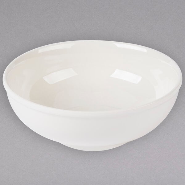 A white Thunder Group melamine Pho noodle bowl with a white rim on a gray surface.