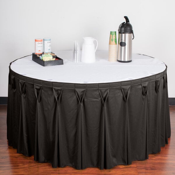 A table with a white top and a charcoal Snap Drape table skirt with Velcro clips.