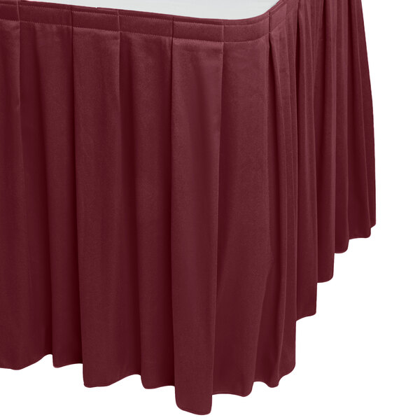 A table with a burgundy Snap Drape table skirt.