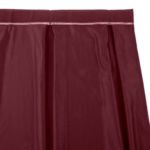 A close up of a burgundy Snap Drape box pleat table skirt.