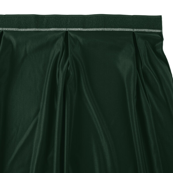 A jade green table skirt with a white band and silver clips.