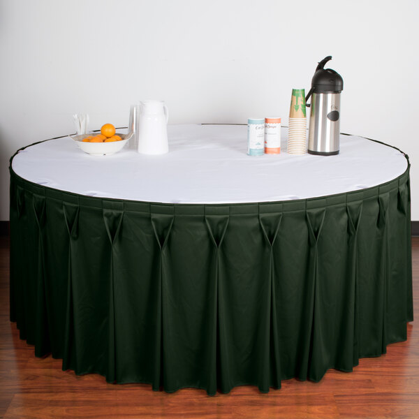 A table with a green Snap Drape Wyndham table skirt with Velcro clips.