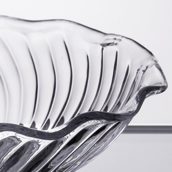 A close up of a clear GET dessert dish with a wavy edge.