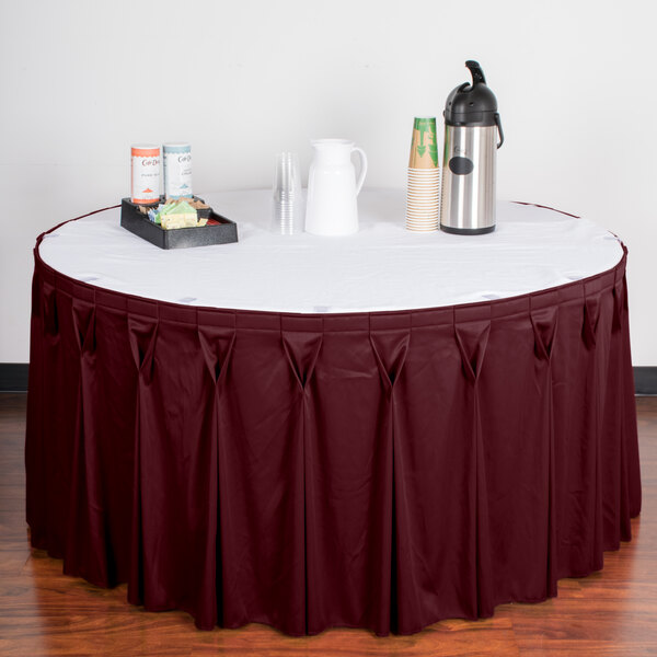 A table with a burgundy Snap Drape table skirt with Velcro clips on it.