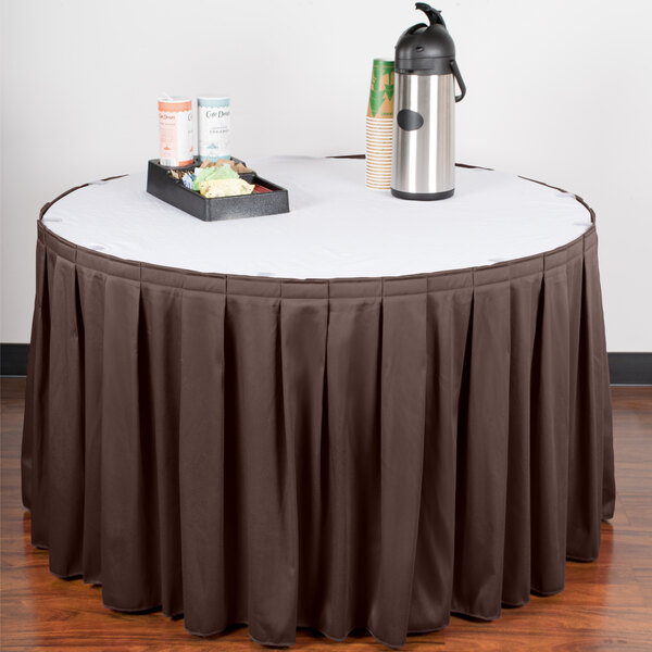 A table with a brown Snap Drape table skirt with Velcro clips and a tray of coffee cups.