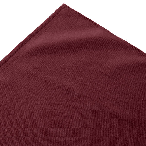 A burgundy box pleat table skirt with Velcro® clips on a white background.