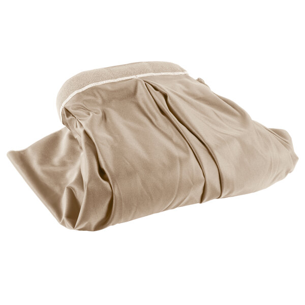 A beige box pleat table skirt in a clear plastic bag with white text.