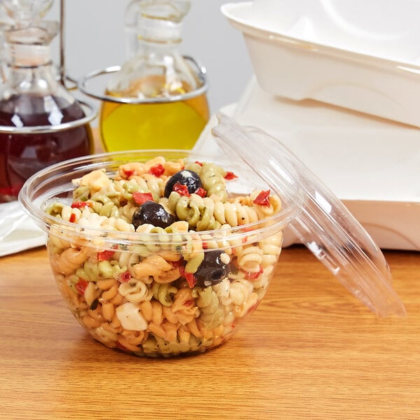 A clear Eco-Products compostable plastic bowl filled with pasta salad and a lid.