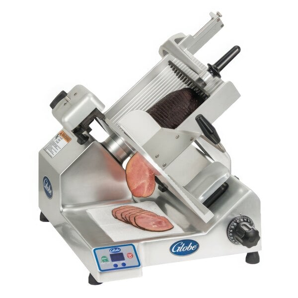 A Globe meat slicer with meat sliced on it.
