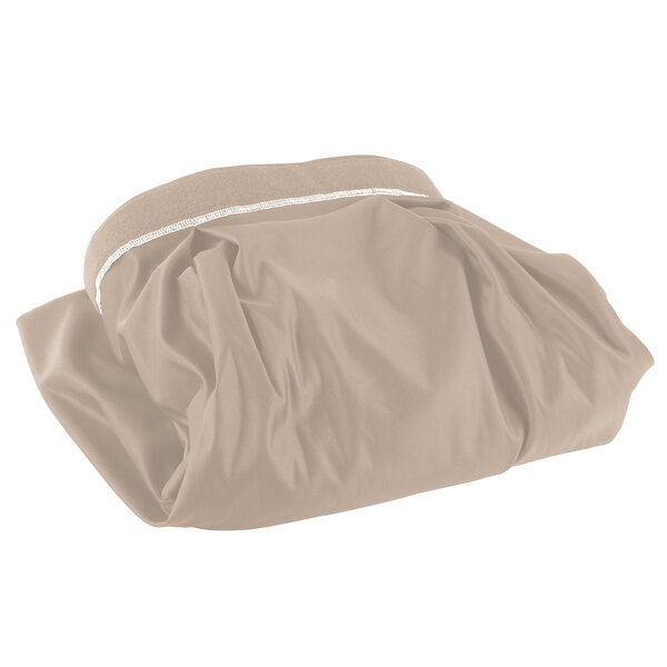 A folded beige table skirt with white trim on a table.