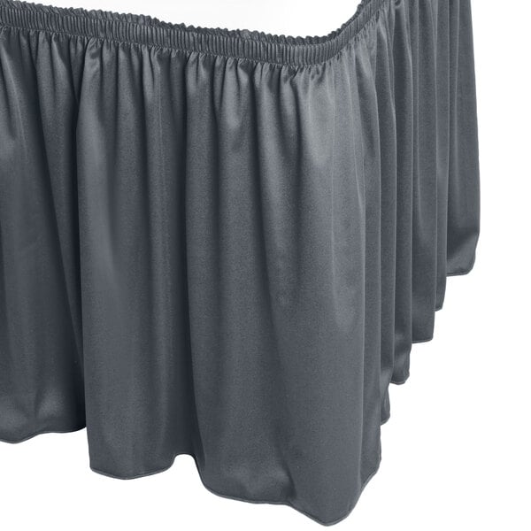 A slate blue Snap Drape Wyndham shirred pleat table skirt on a table.