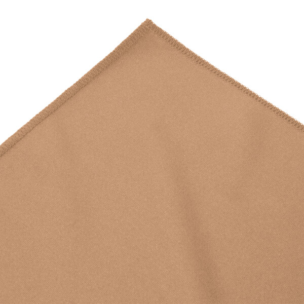 A Snap Drape sandalwood table skirt with bow tie pleats on a table.