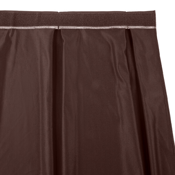 A brown box pleat table skirt with a white stripe.