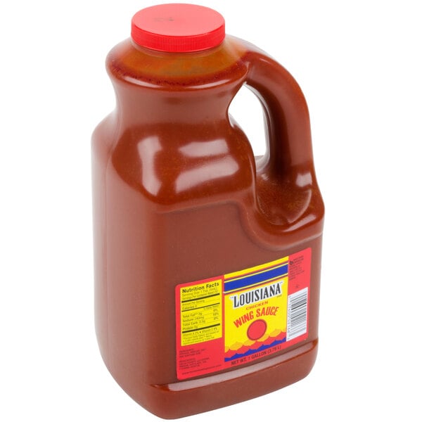 A gallon jug of Louisiana Wildly Wicked Buffalo Wing Sauce with a red lid.