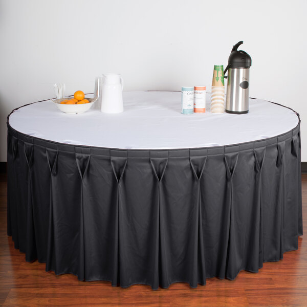a table with a white tablecloth and a bowl of oranges