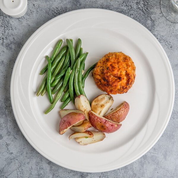 A white Libbey porcelain plate with potatoes, green beans, and a meat patty.