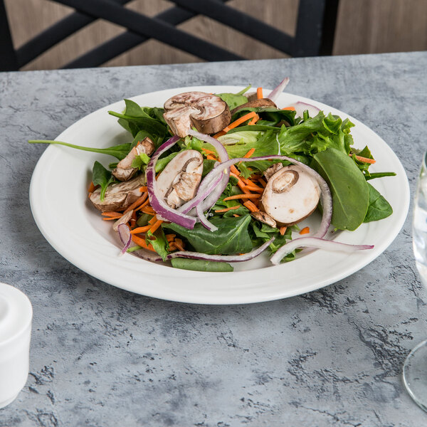 A Libbey white porcelain plate with a salad of mushrooms, onions, and carrots.