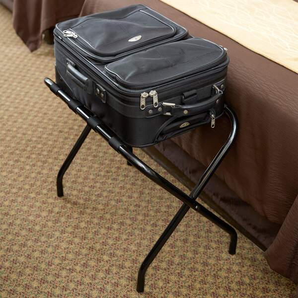 A black suitcase on a black CSL Flat Top Series metal luggage rack.