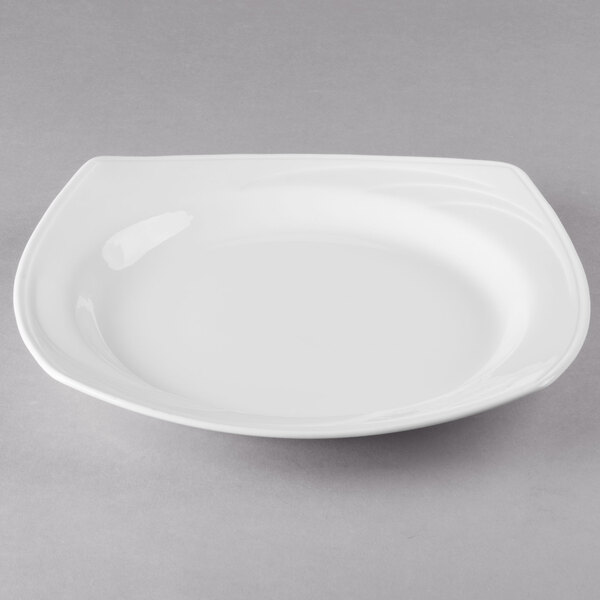 A white plate with a Libbey white square bowl on it.