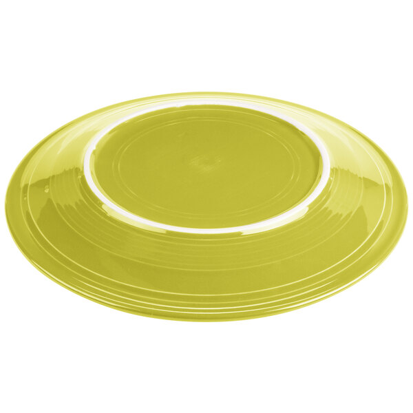 A close up of a Fiesta lemongrass yellow china chop plate with a white band.
