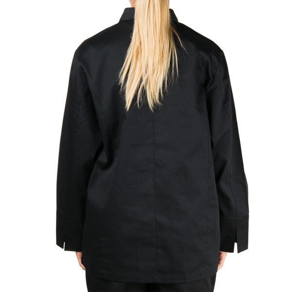 A woman wearing a black Chef Revival chef jacket with a chest pocket.