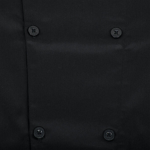 A close up of a black Chef Revival short sleeve chef jacket with buttons and a mesh back.
