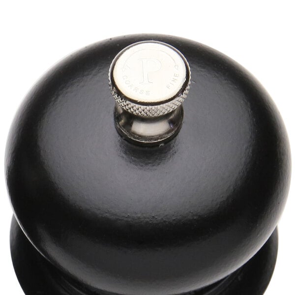 A black round object with a silver knob.