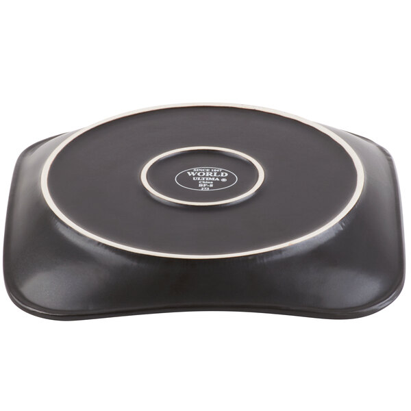 A Libbey stoneware plate with square detailing on a table in a home kitchen.